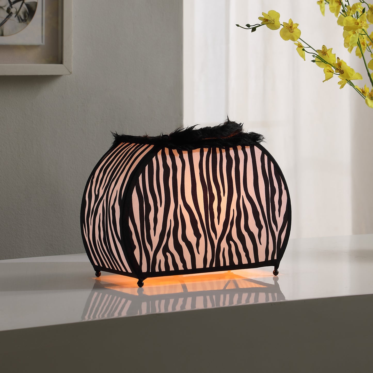 Curved table lamp with black and white zebra print fabric and fluffy black trim