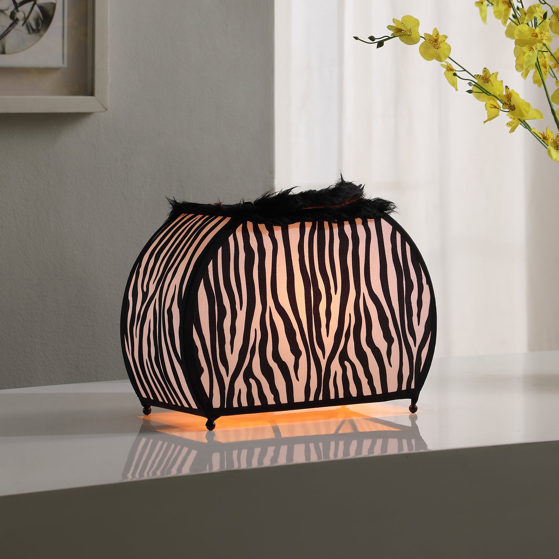 Curved table lamp with black and white zebra print fabric and fluffy black trim