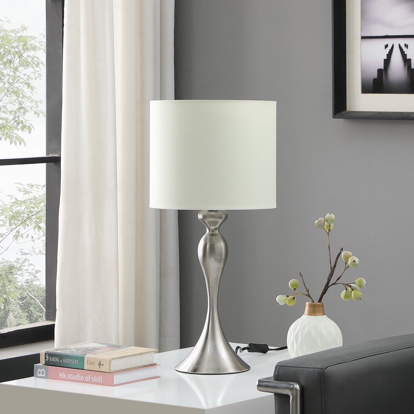 Modern brushed nickel table lamp with a cream fabric shade ideal for bedside tables