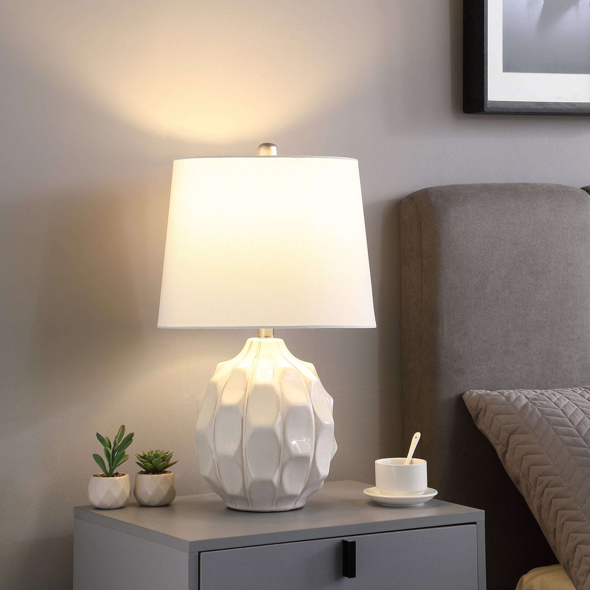Sculptural white ceramic table lamp with textured base and white linen shade