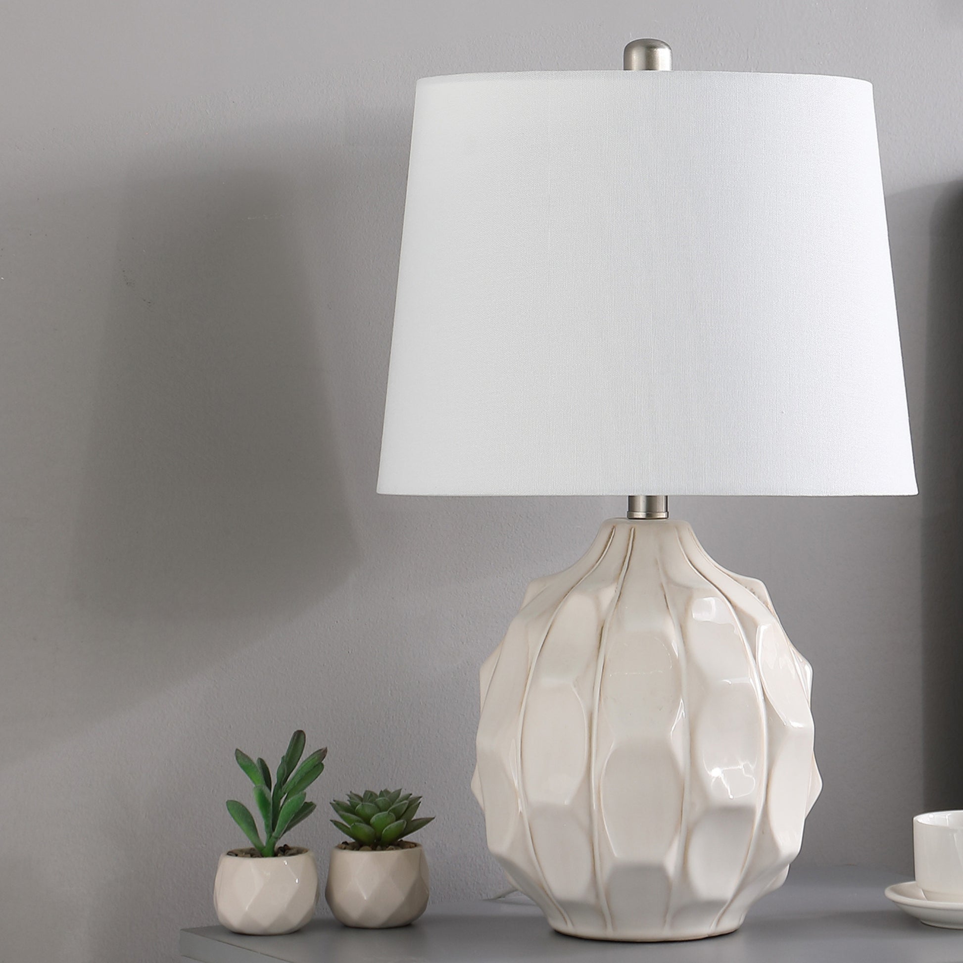 Cream ceramic table lamp with textured base and white linen shade