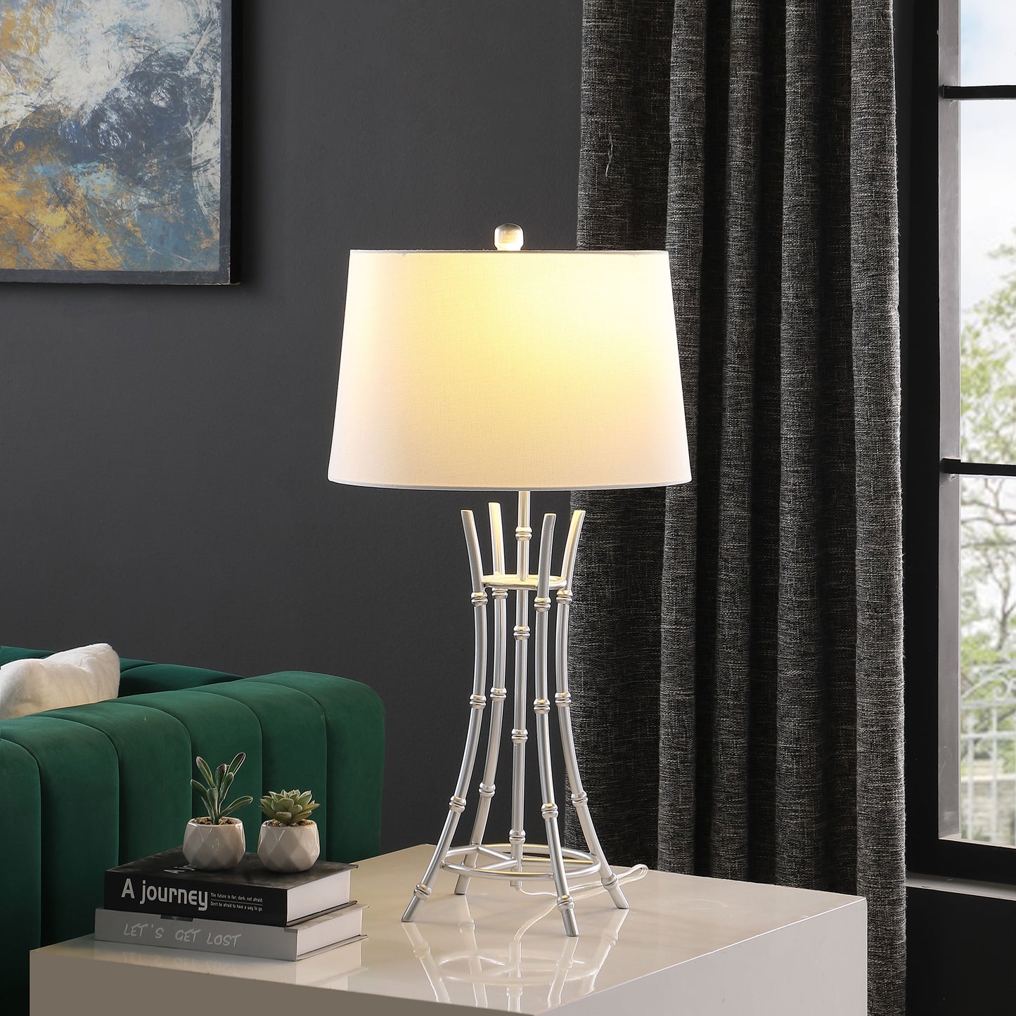 Modern silver table lamp with a white fabric shade on a white table elegant accent lighting