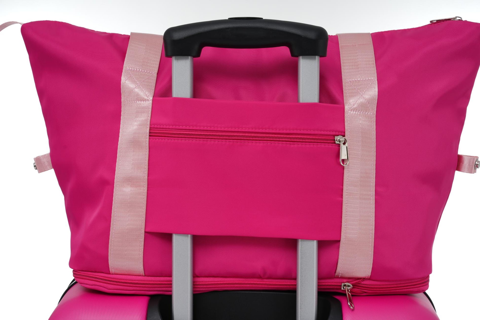 Bright pink travel duffel bag with light pink straps and silver hardware attached to luggage handle