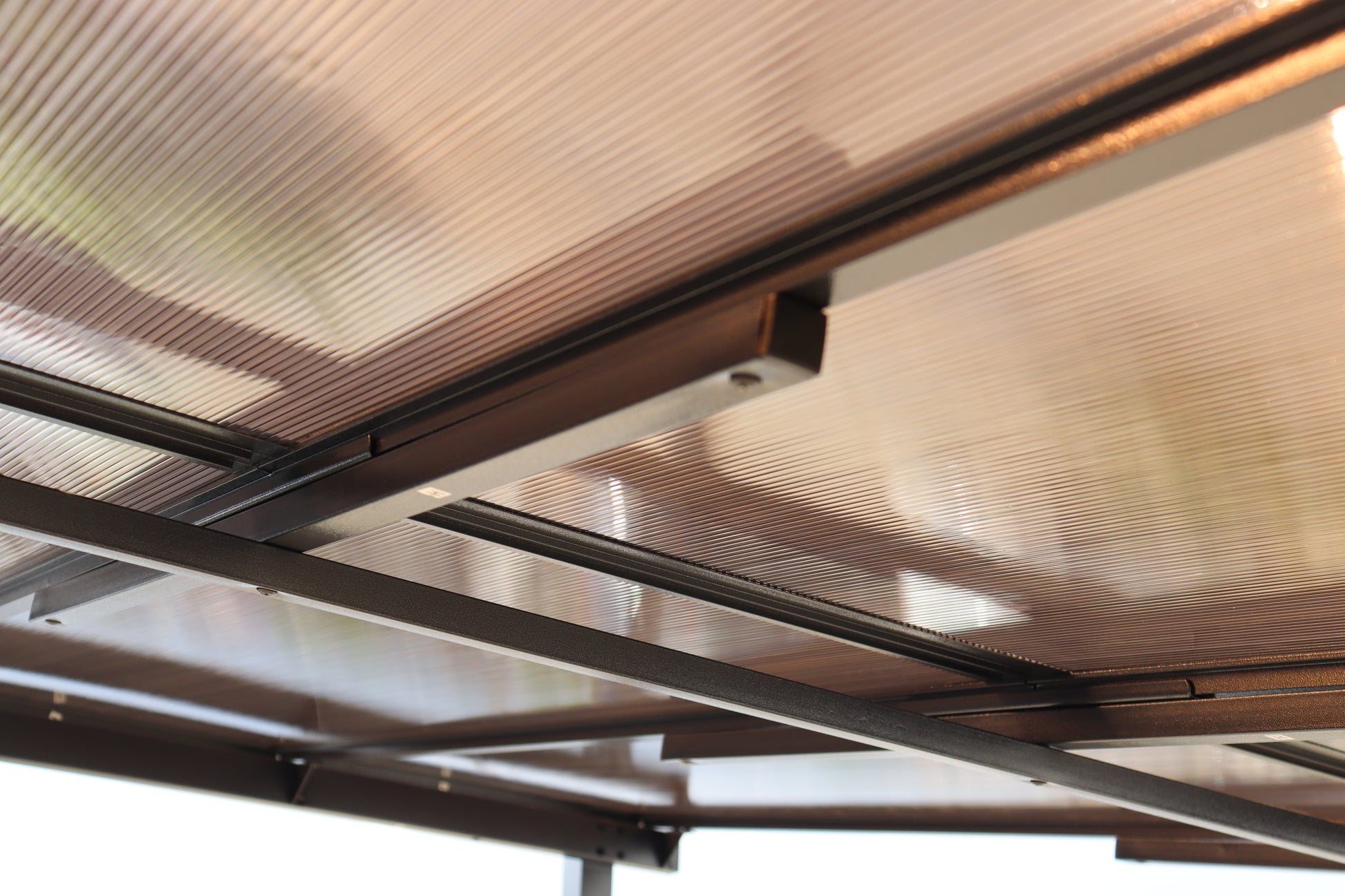Bronze aluminum frame supporting corrugated polycarbonate roofing panels