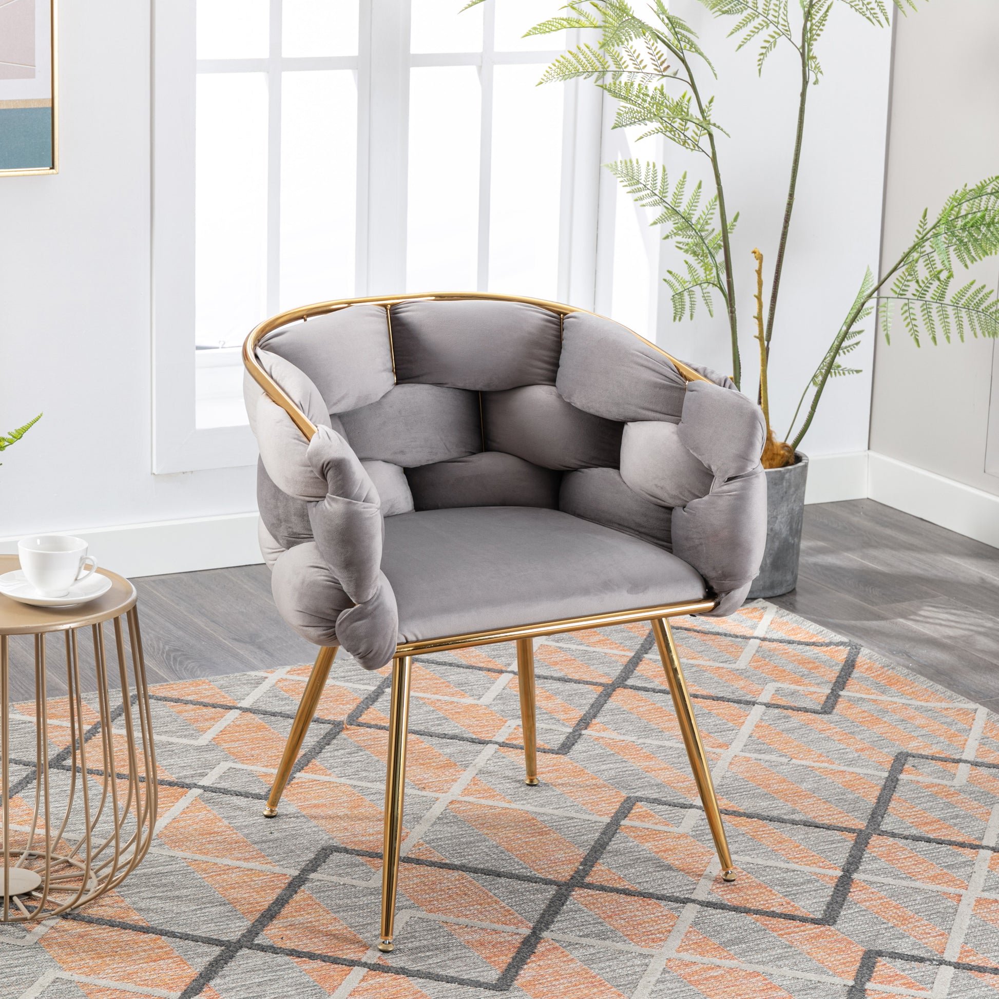 Grey velvet accent chair with knotted arms and gold metal legs perfect for modern living rooms