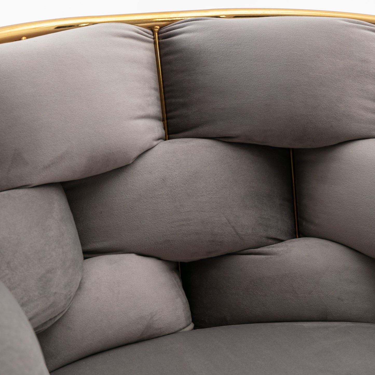Plush grey velvet armchair with gold metal frame and tufted cushions