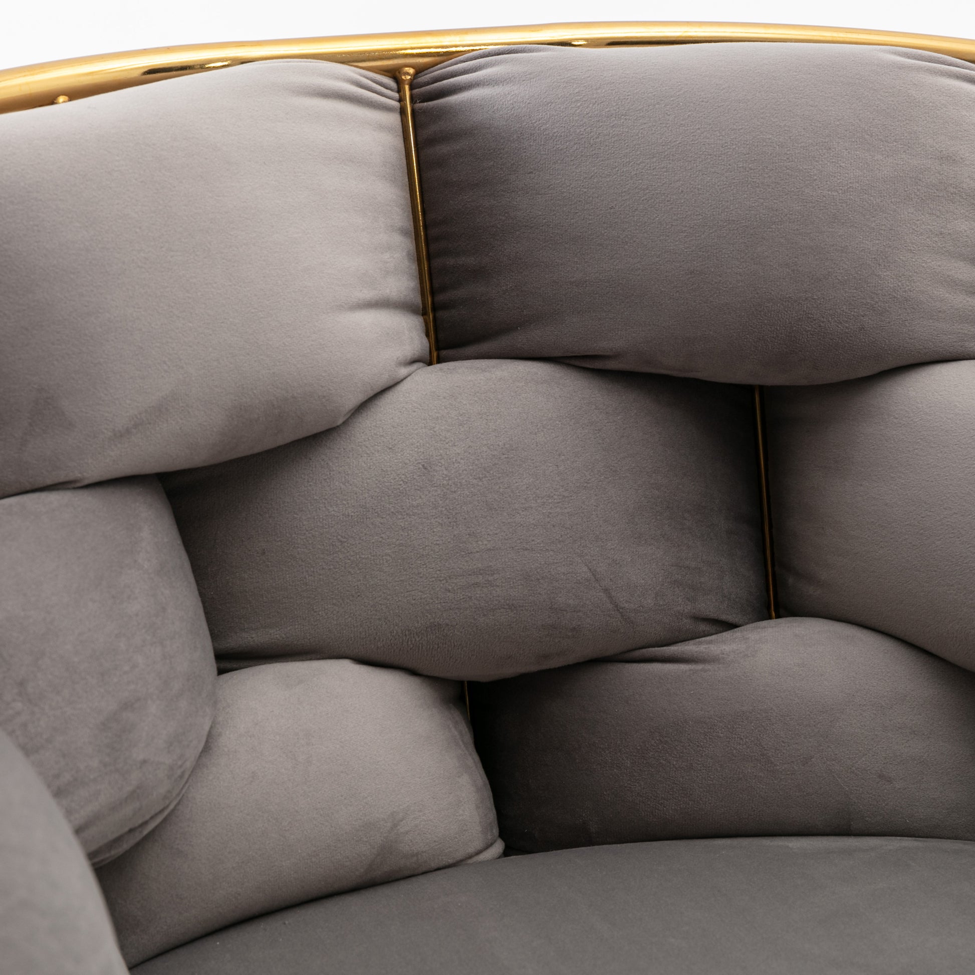 Plush grey velvet armchair with gold metal frame and tufted cushions