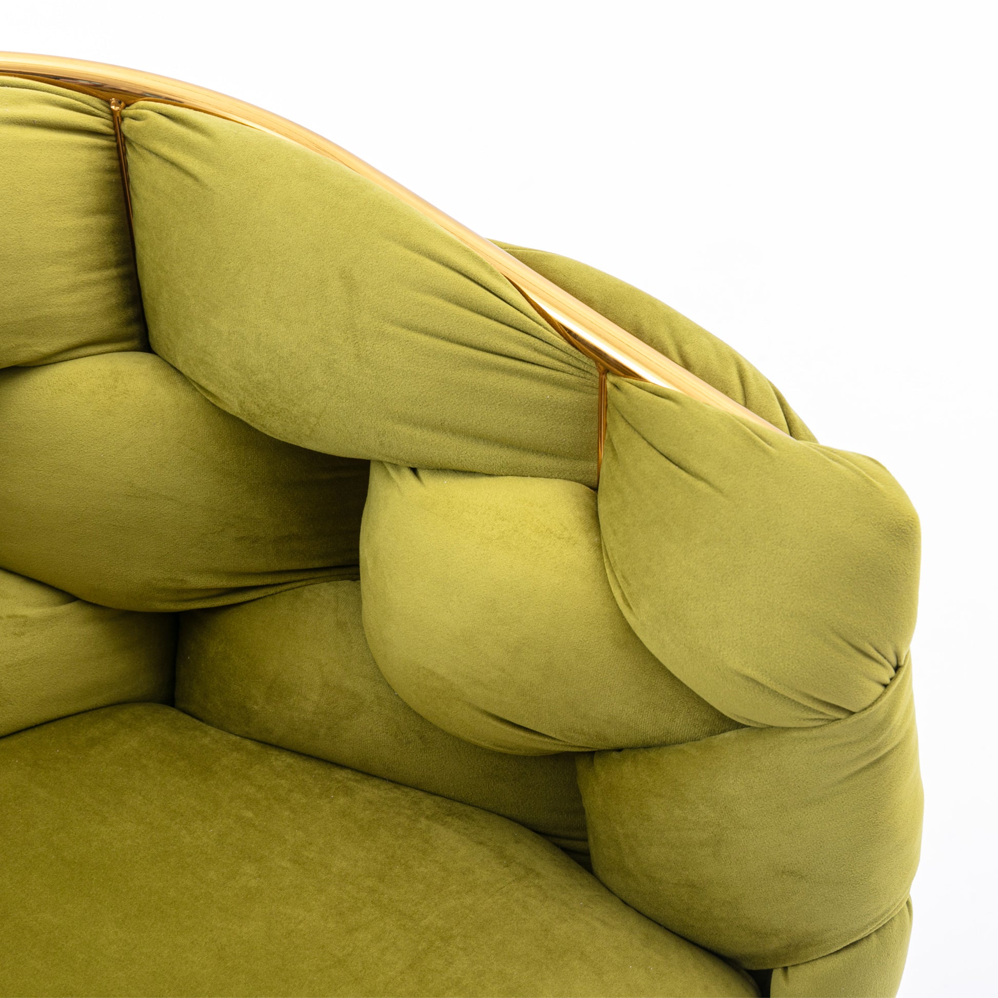Closeup of plush olive green velvet armchair with tufted detailing and a gold metal frame accent
