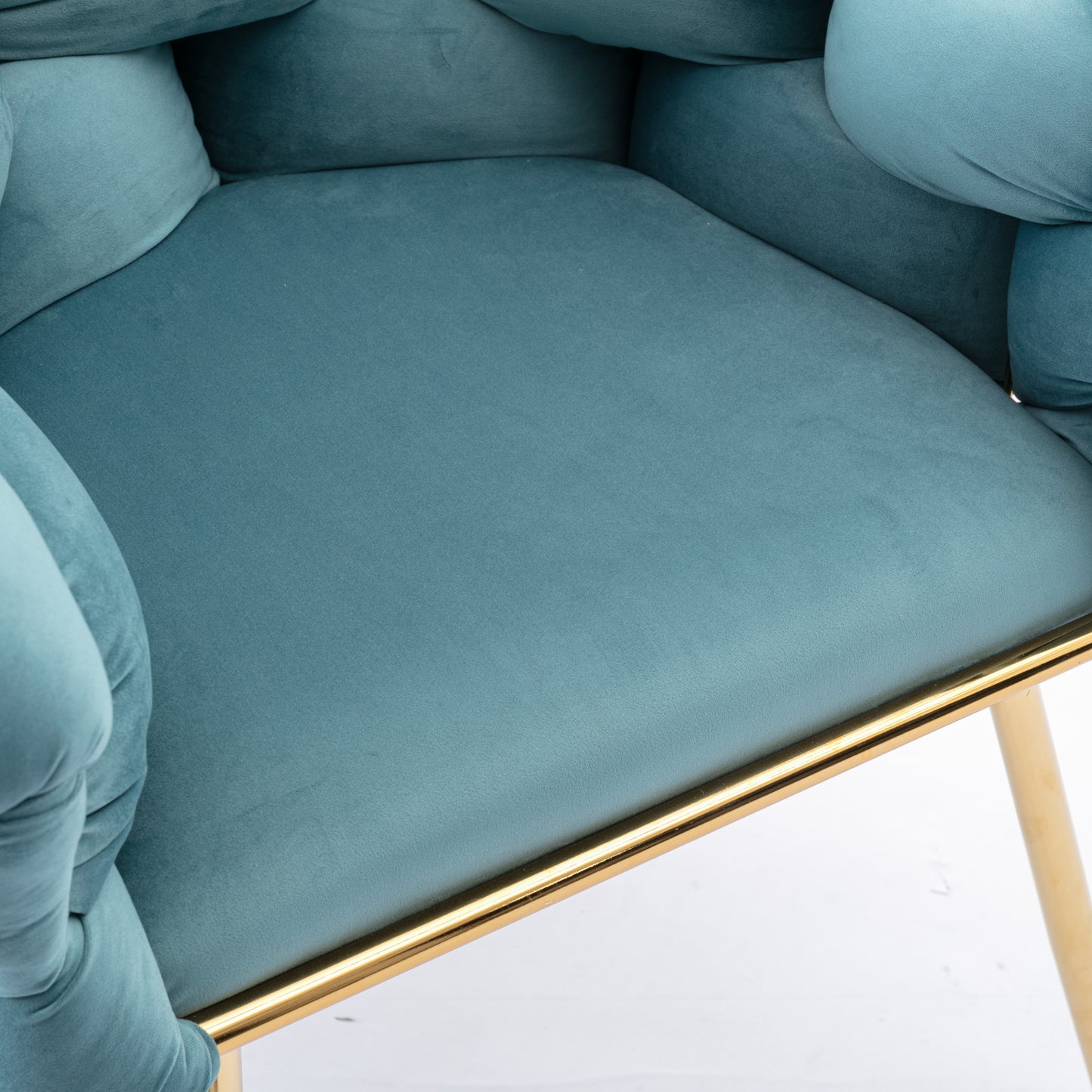 Closeup of a plush teal velvet accent chair with gold trim and legs