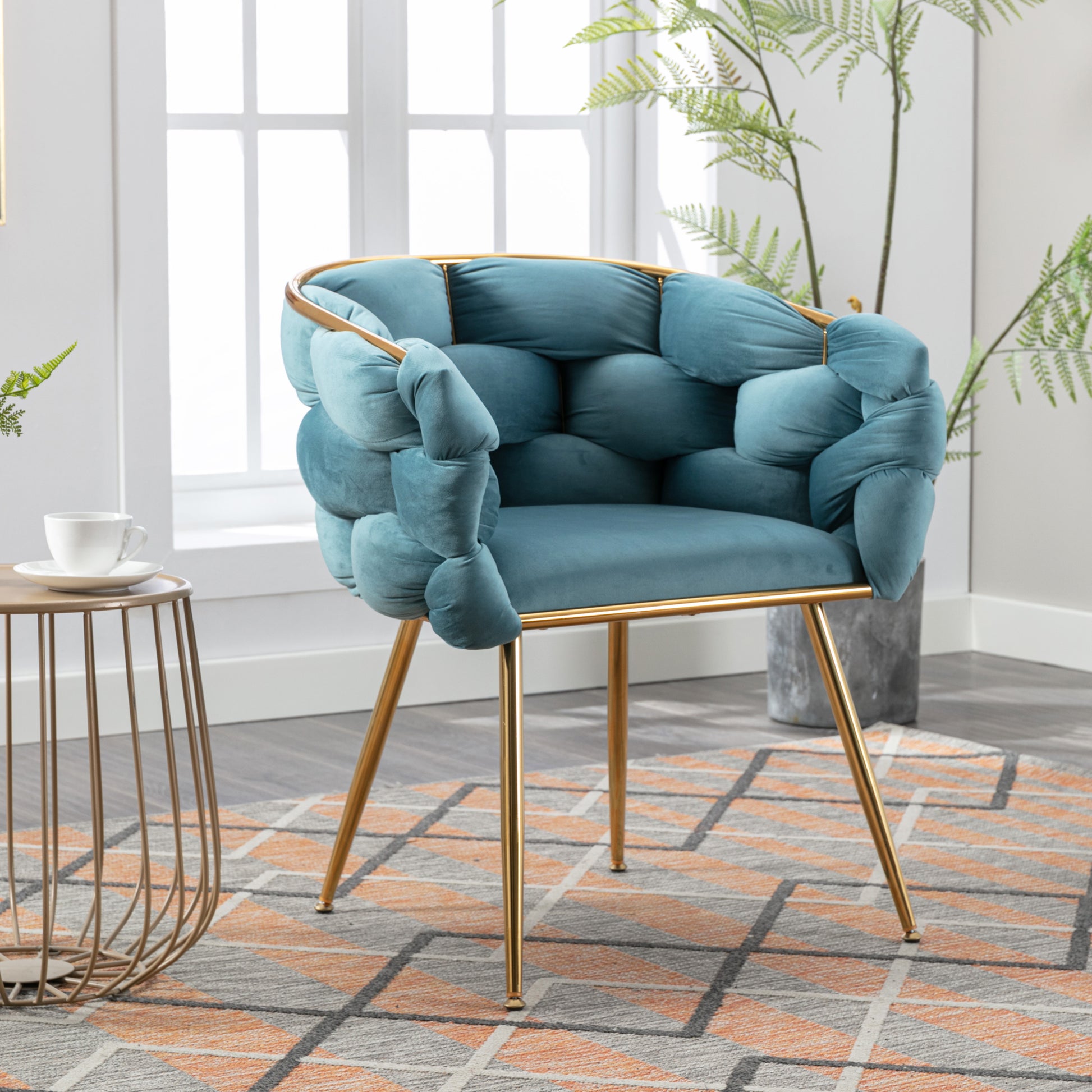 Teal velvet armchair with unique knotted arms and gold metal legs