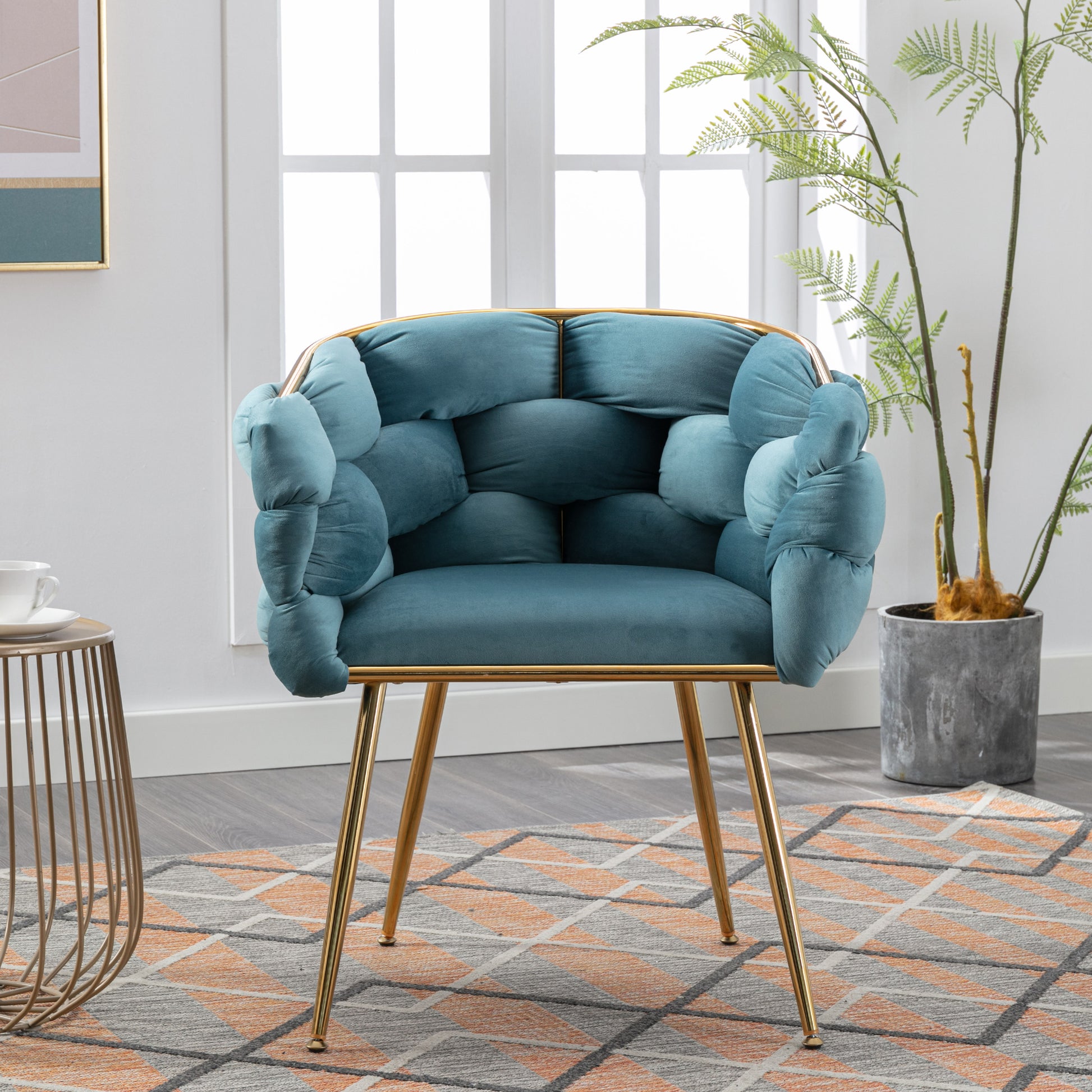 Plush teal velvet accent chair with a unique quilted design and gold metal legs