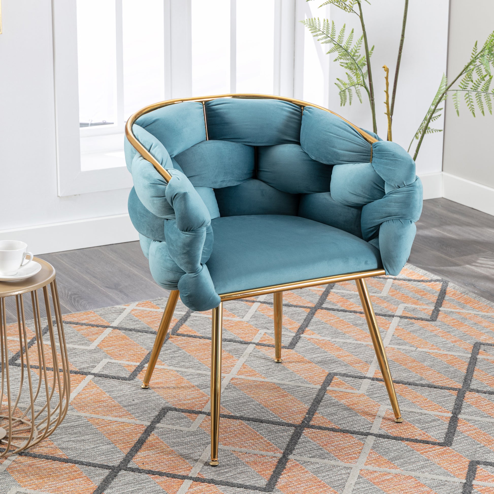 Teal velvet accent chair with unique knotted armrests and gold metal legs