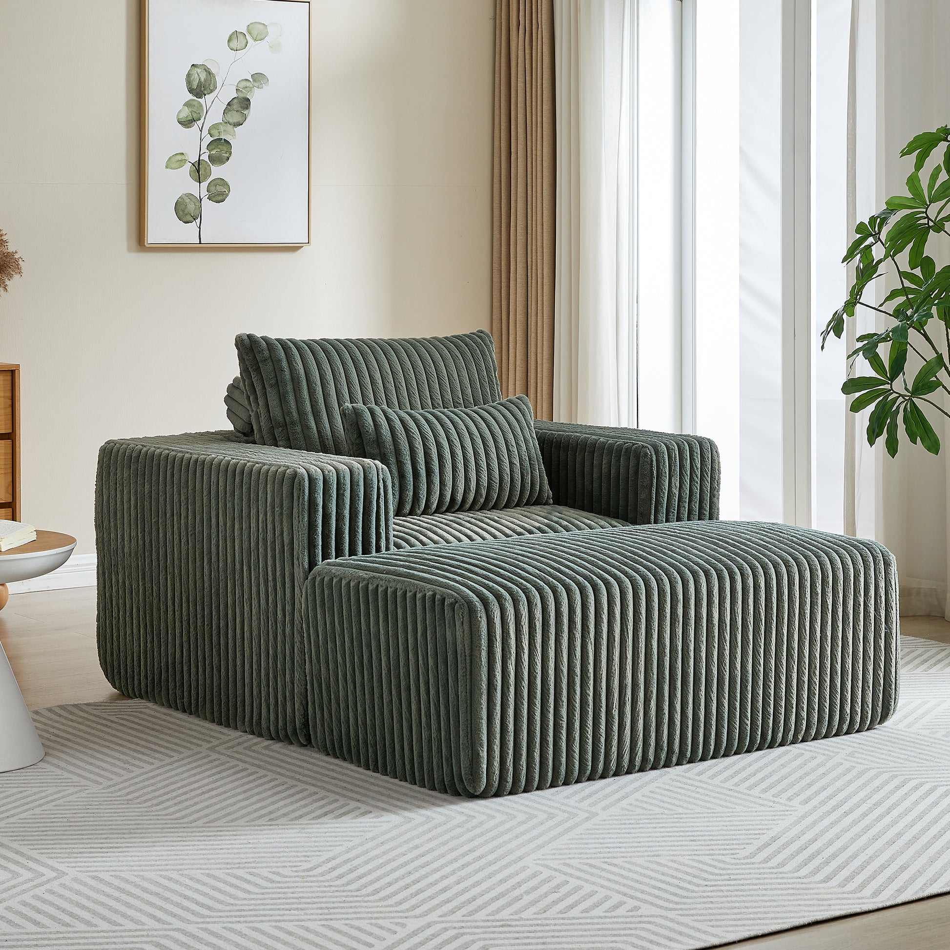 Comfortable green corduroy armchair with plush cushions and matching ottoman
