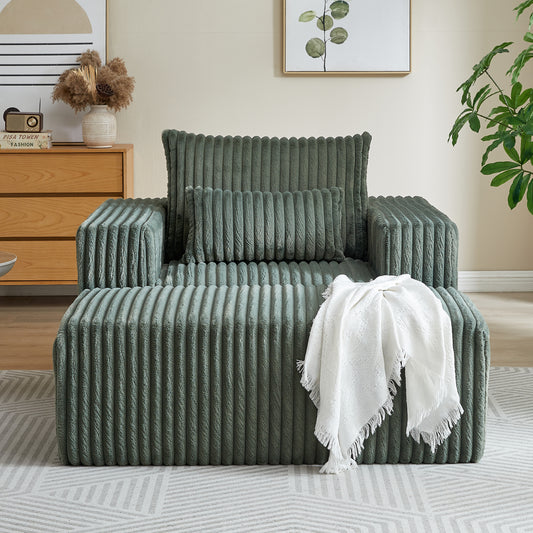 Comfortable corduroy armchair in a deep sage green with plush texture and matching accent pillow