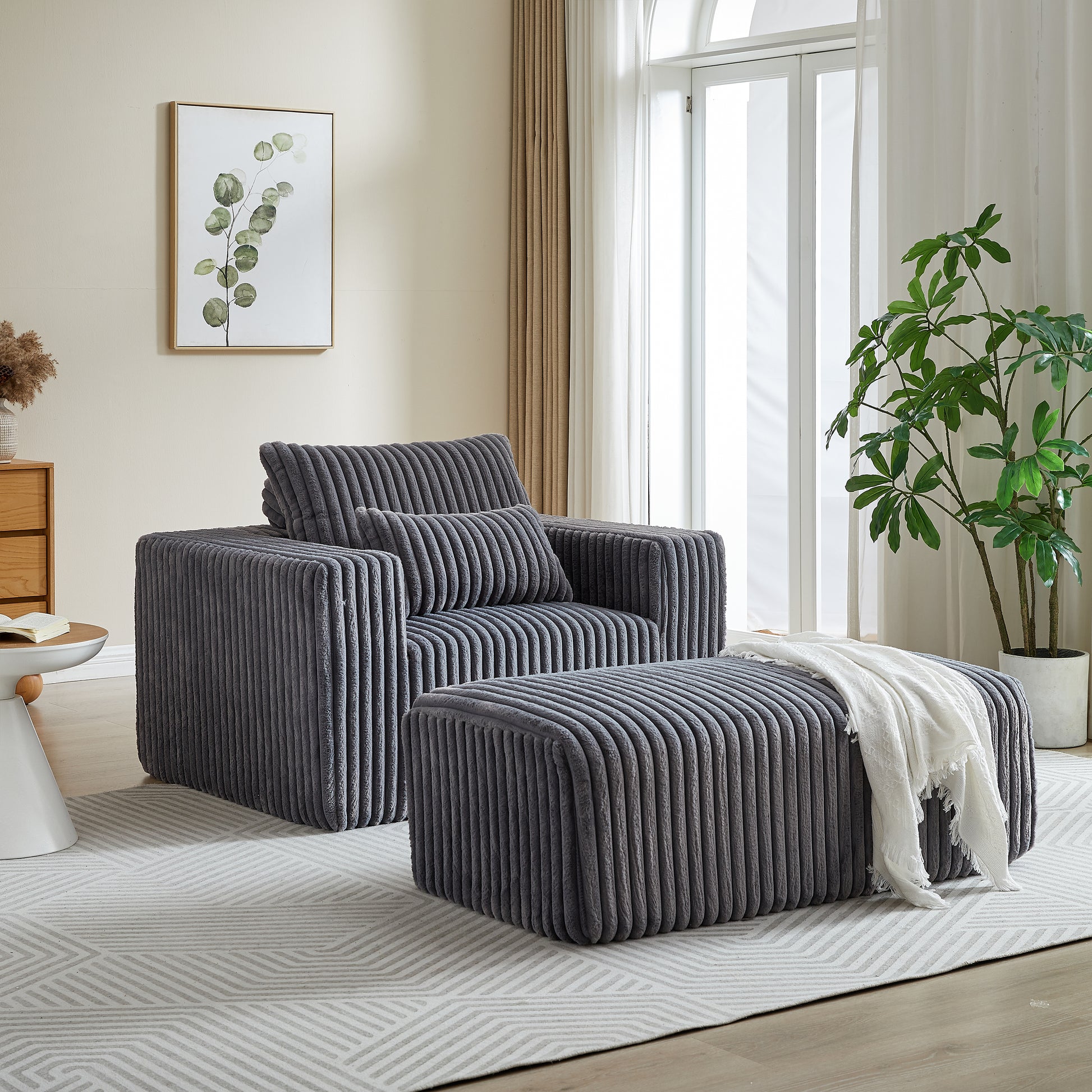 Plush grey corduroy armchair with matching ottoman and decorative throw