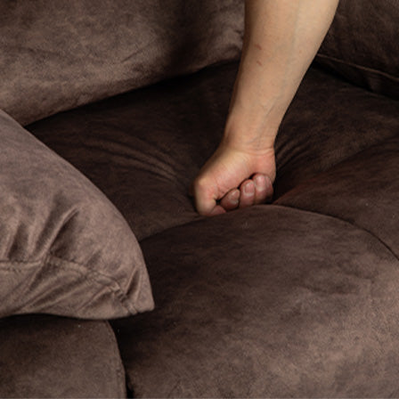 Brown chenille fabric sofa cushion showing plush comfort with hand pressing in