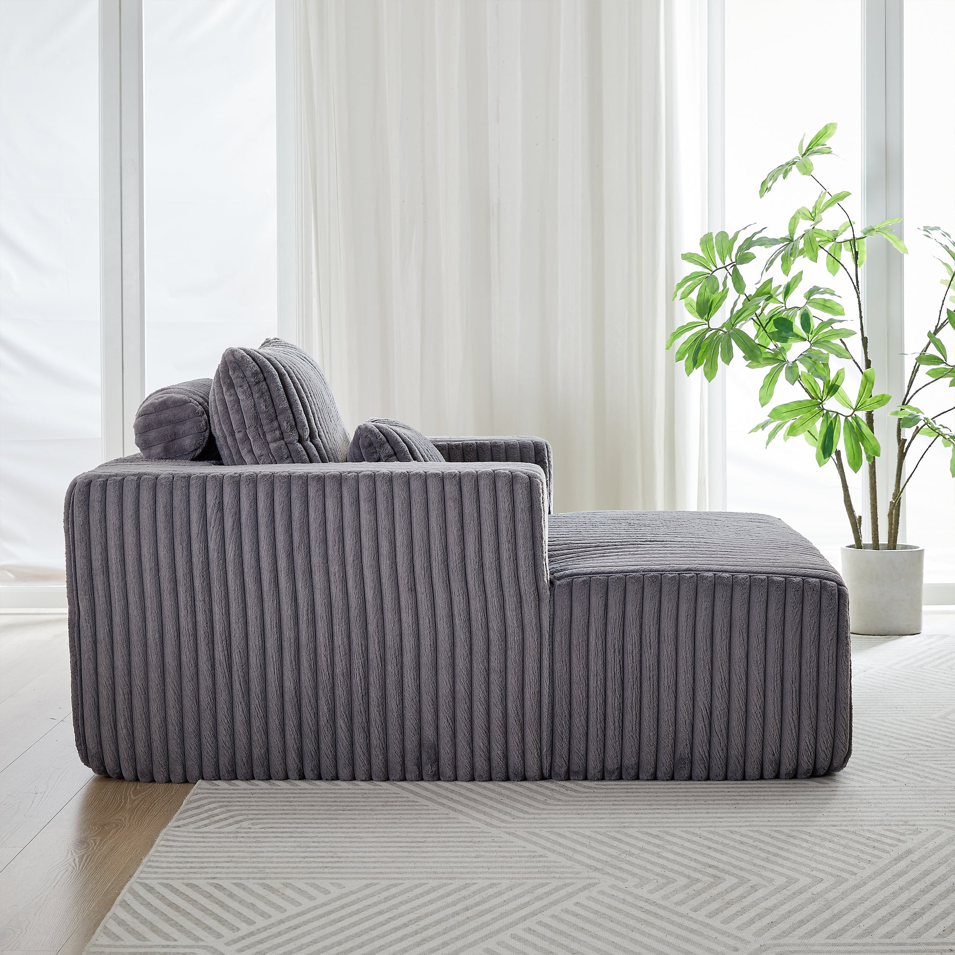 Plush grey corduroy sectional sofa with rounded arms and removable pillows for modern living rooms