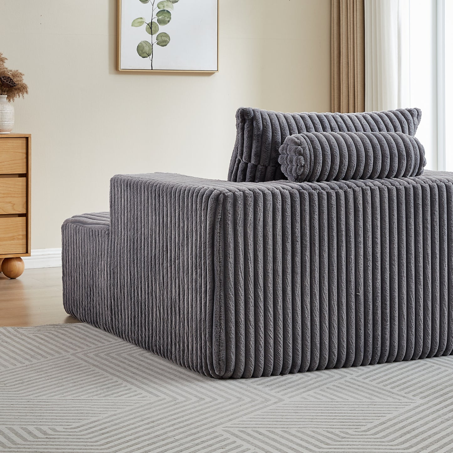 Plush grey corduroy sectional sofa with bolster and square pillows for comfortable living room seating