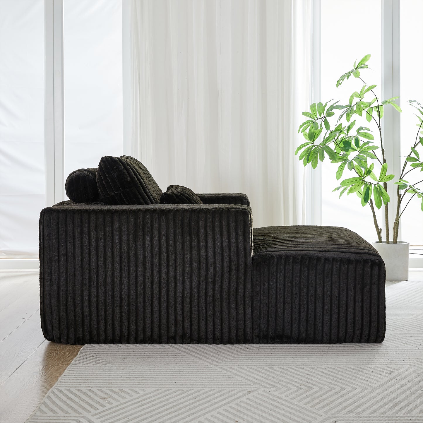 Dark green corduroy sectional sofa with plush throw pillows and ottoman