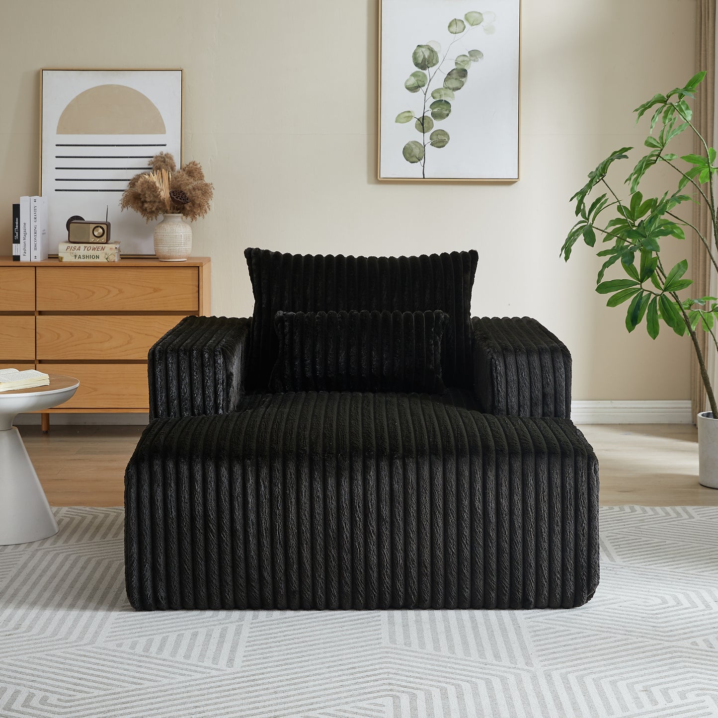 Plush black corduroy armchair with matching lumbar and square throw pillows a modern lounge chair