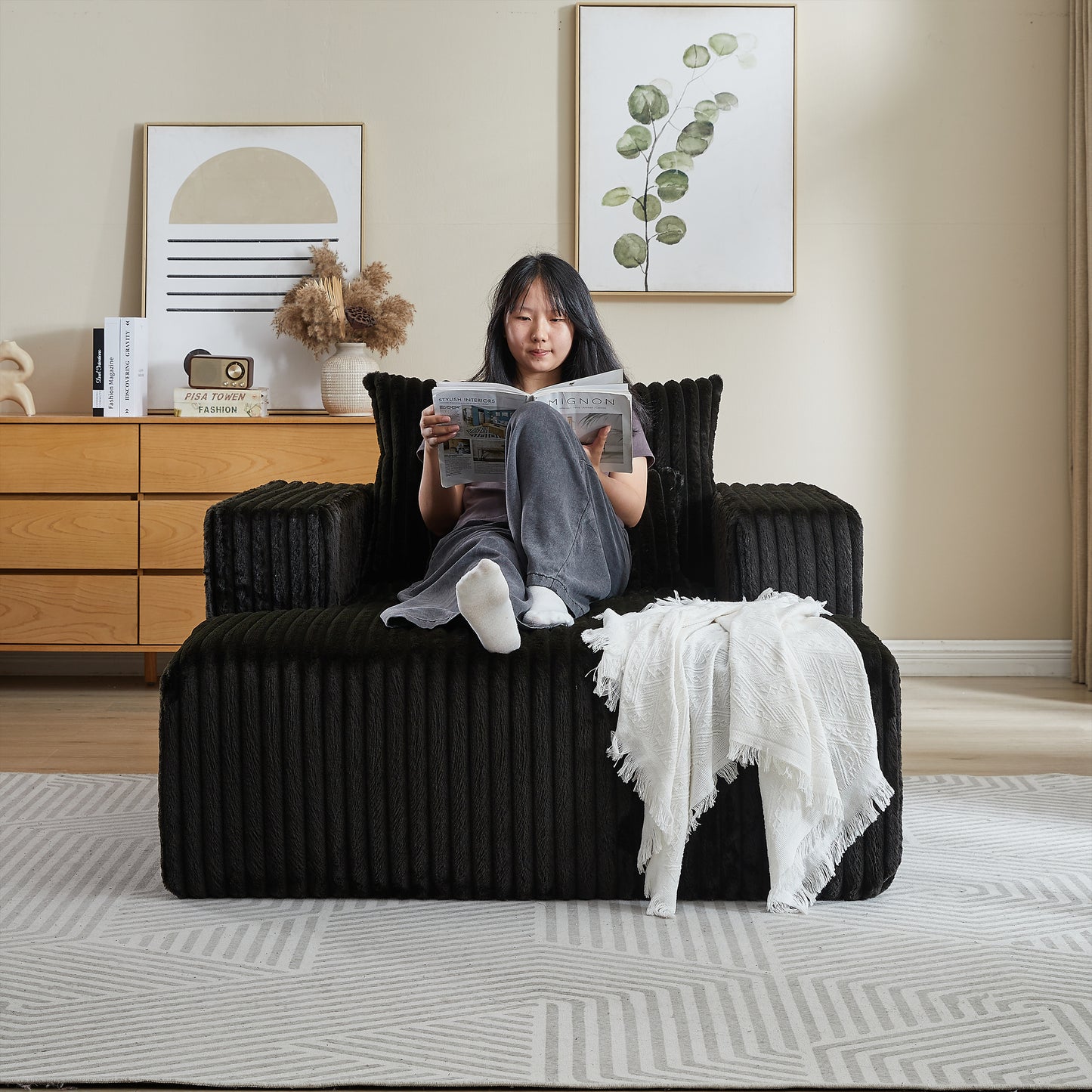 Black corduroy armchair with a plush texture perfect for a cozy living room setup
