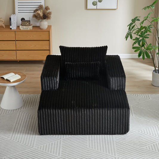 Plush black corduroy armchair with two throw pillows perfect for a cozy living room