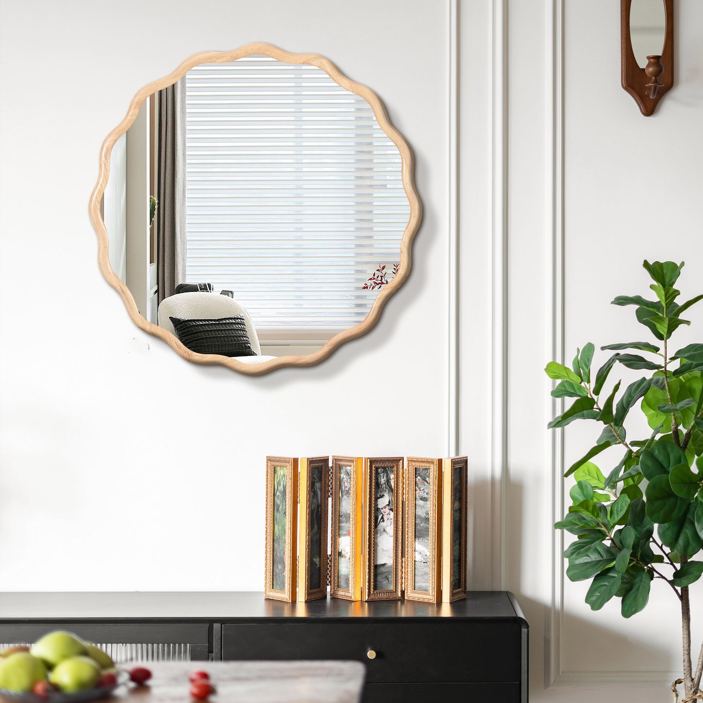 Scalloped wood framed wall mirror reflecting a bright window with blinds