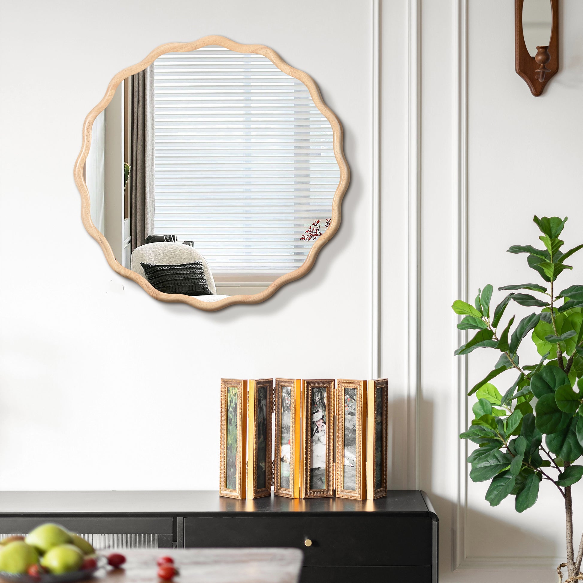 Scalloped wood framed wall mirror reflecting a bright window with blinds