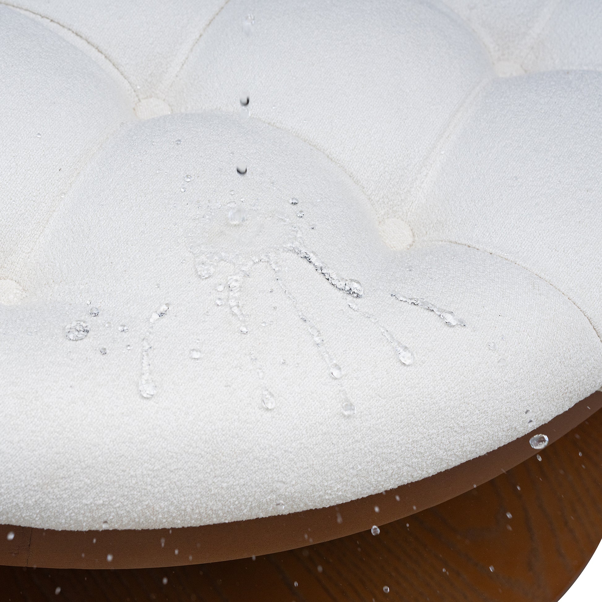Closeup of white fabric ottoman with water beads showing waterrepellent properties