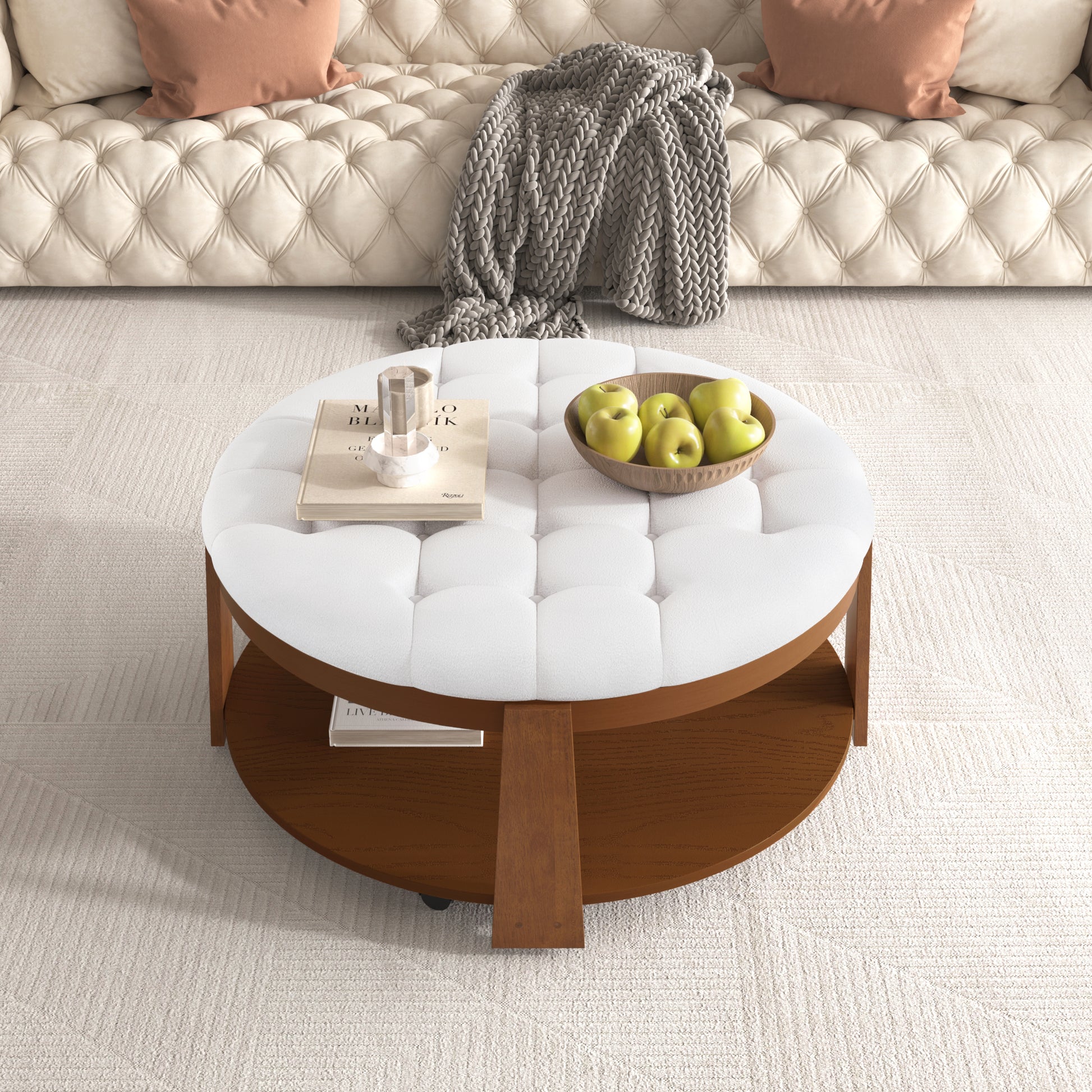 Tufted white fabric ottoman coffee table with wooden base and basket of apples