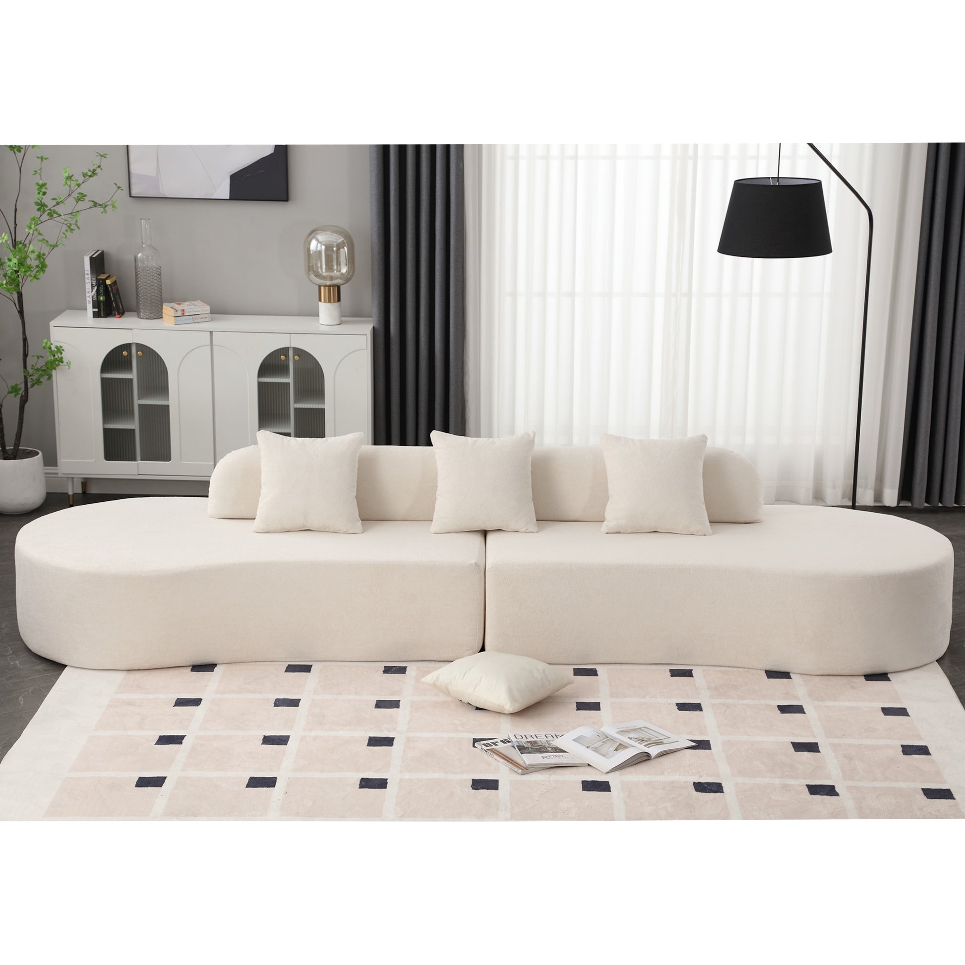 Plush boucle modular sofa in cream with rounded edges and scattered cushions