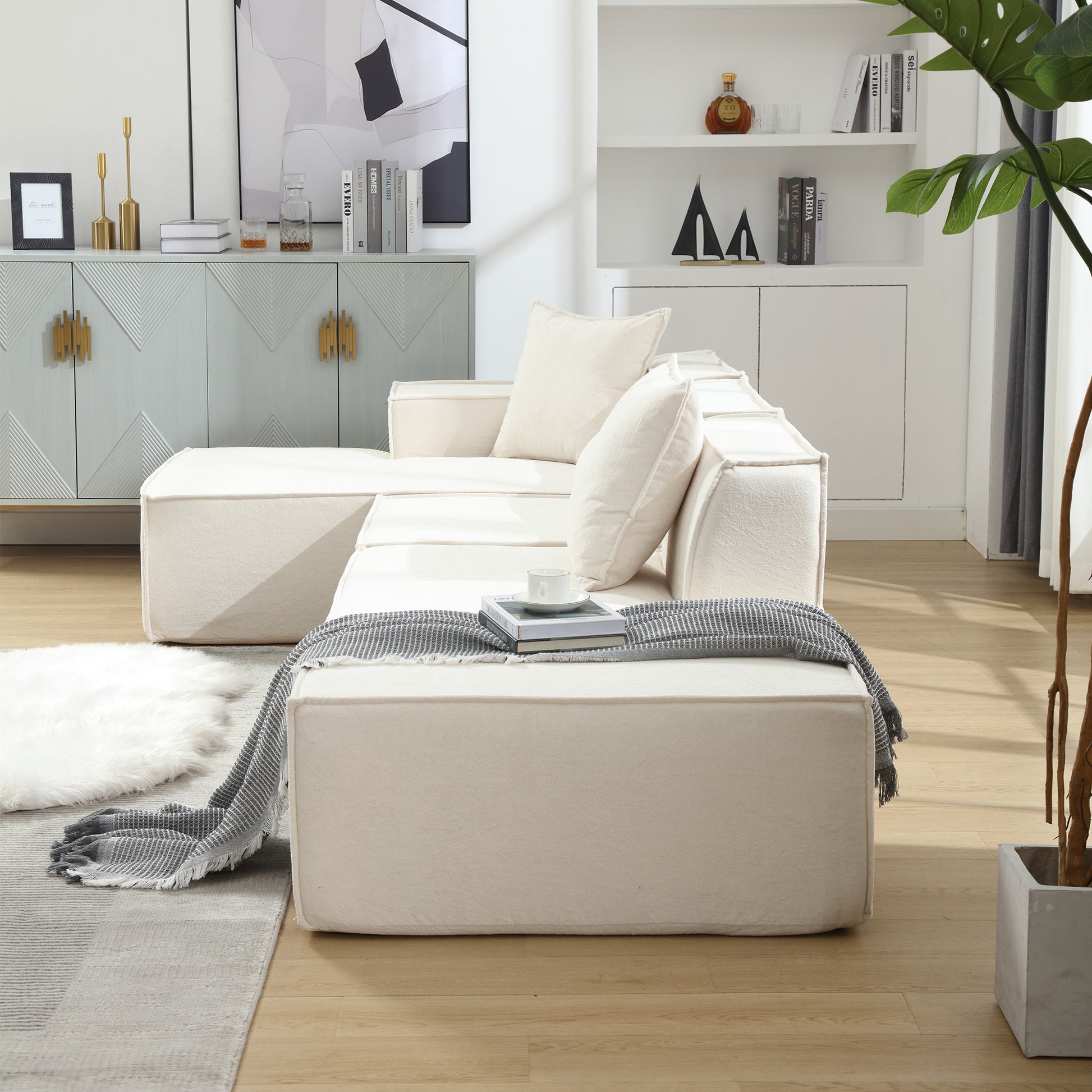 Cream modular sectional sofa with plush cushions and a charcoal throw