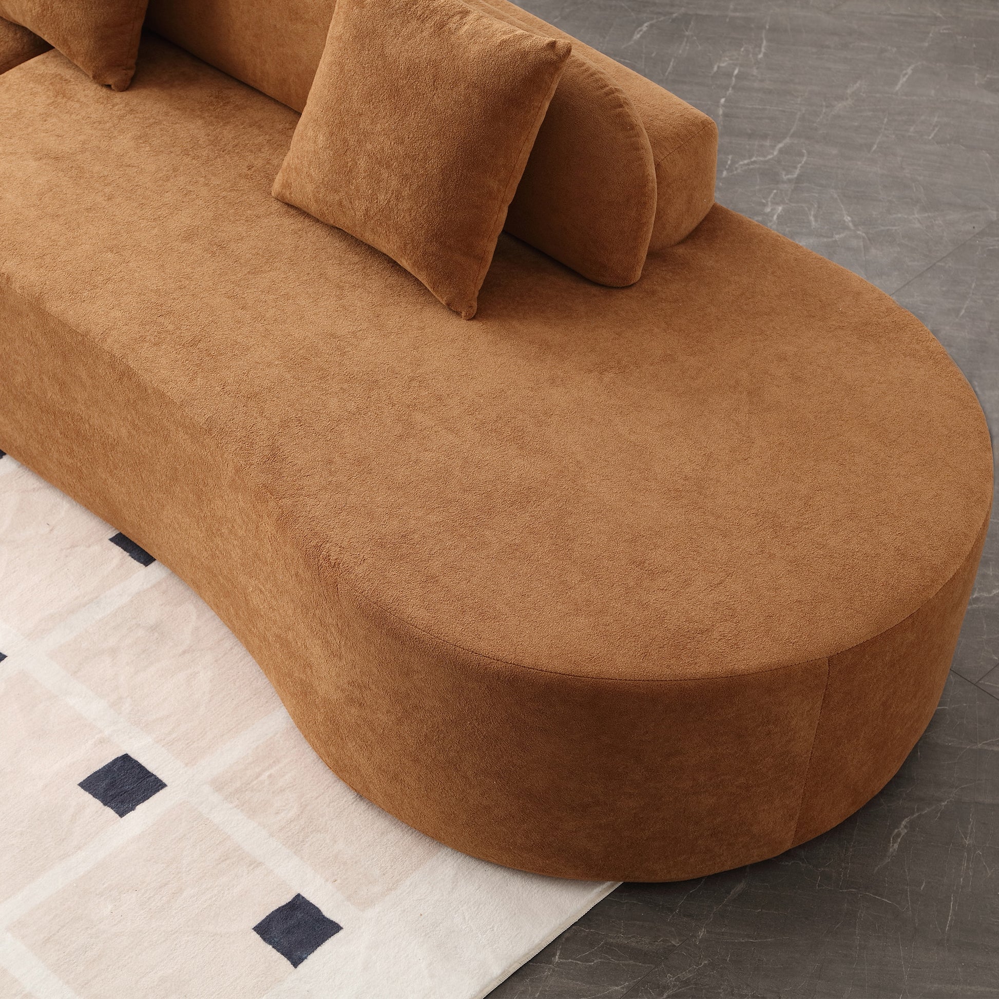 Suede chaise lounge in warm tan with plush pillows for ultimate comfort
