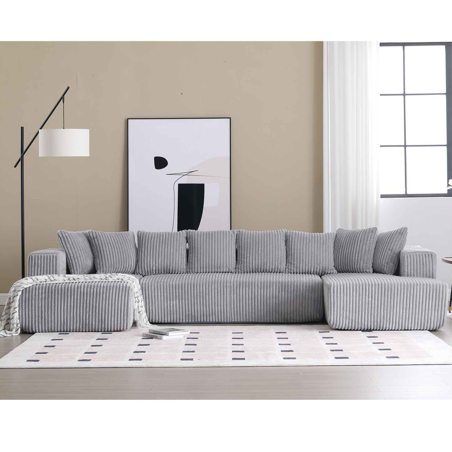 Plush grey corduroy sectional sofa with textured cushions and a matching ottoman ideal for a modern living room