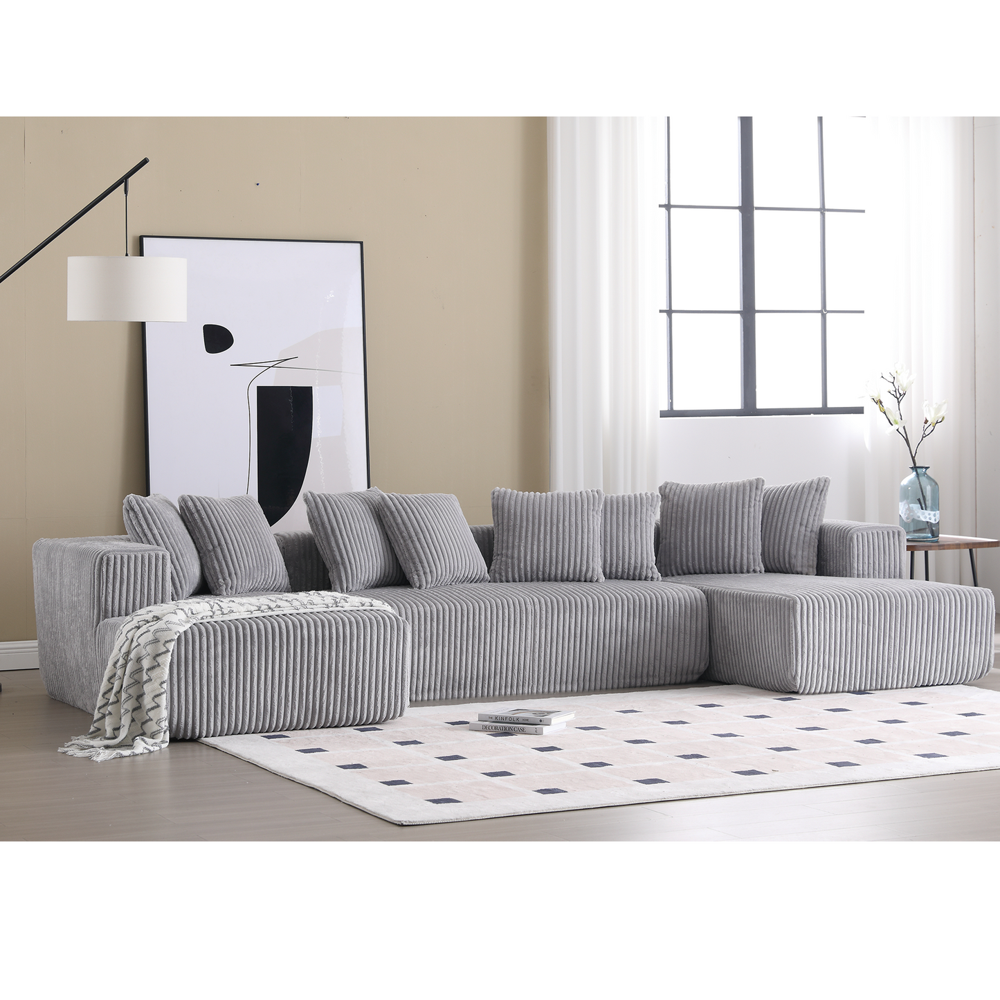 Grey corduroy sectional sofa with plush pillows and ottoman
