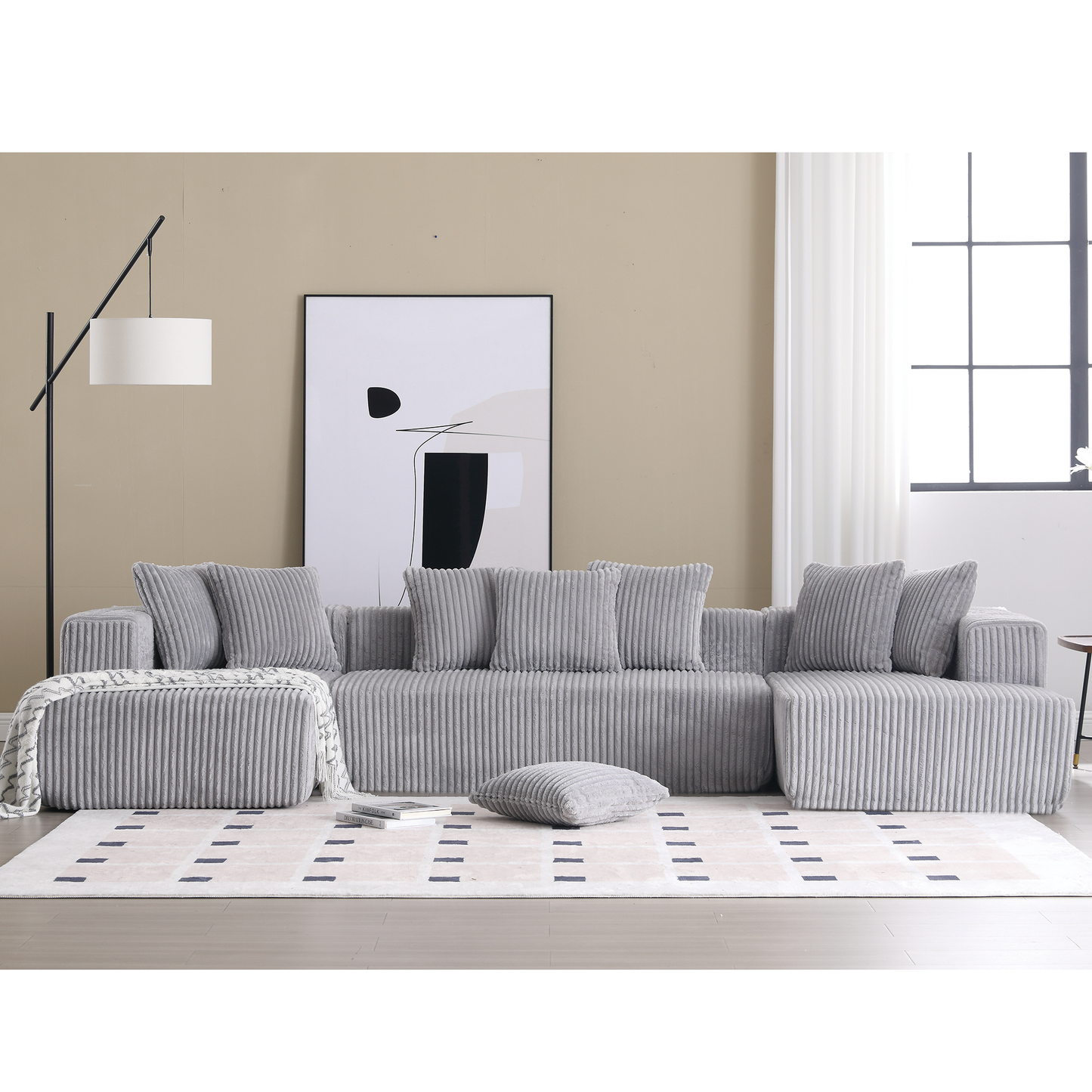 Grey corduroy sectional sofa with plush pillows and matching ottoman for a modern living room