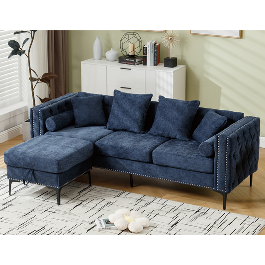 Deep blue tufted sectional sofa with silver nailhead trim featuring plush cushions and a chaise ottoman for living room seating