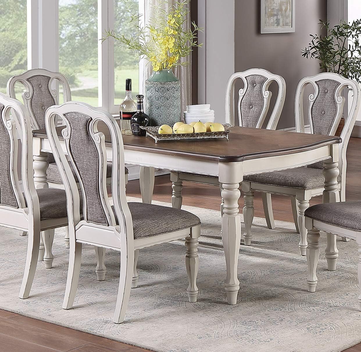 Antique white dining chairs with grey upholstered seats arranged around a woodtop table