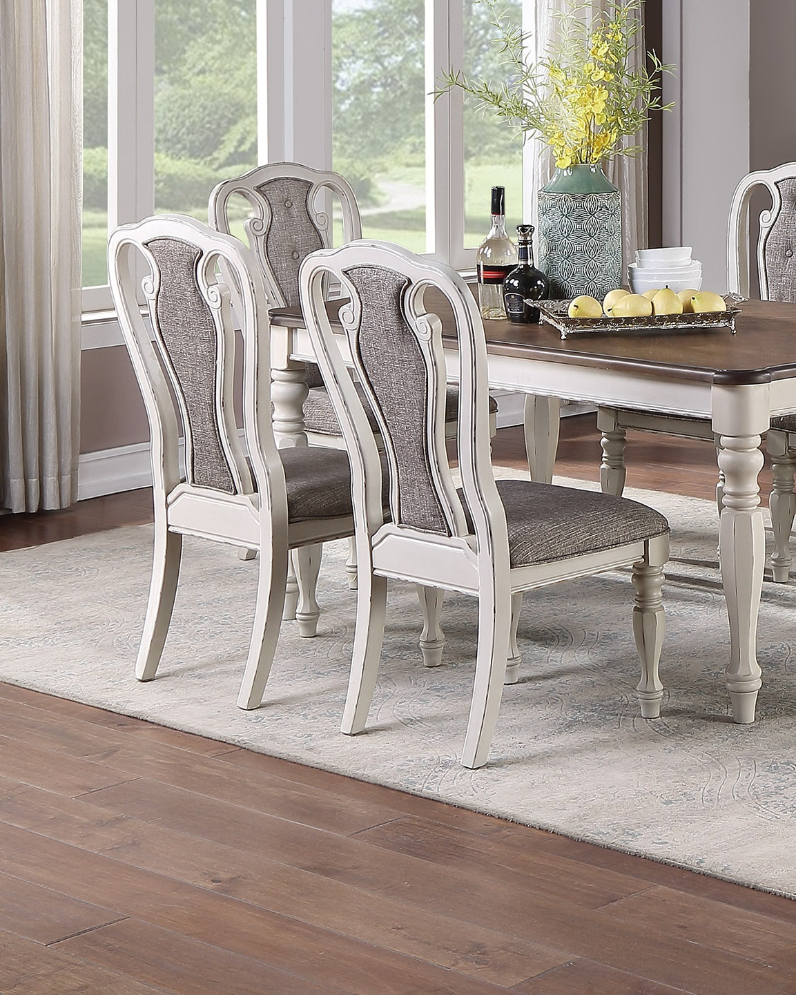 White upholstered dining chairs with scrolled backrests and grey seats