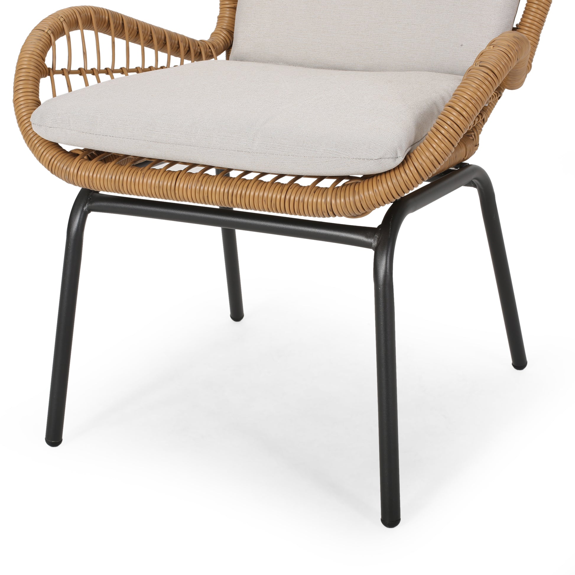 Closeup of a modern wicker chair with black metal legs and a beige cushion