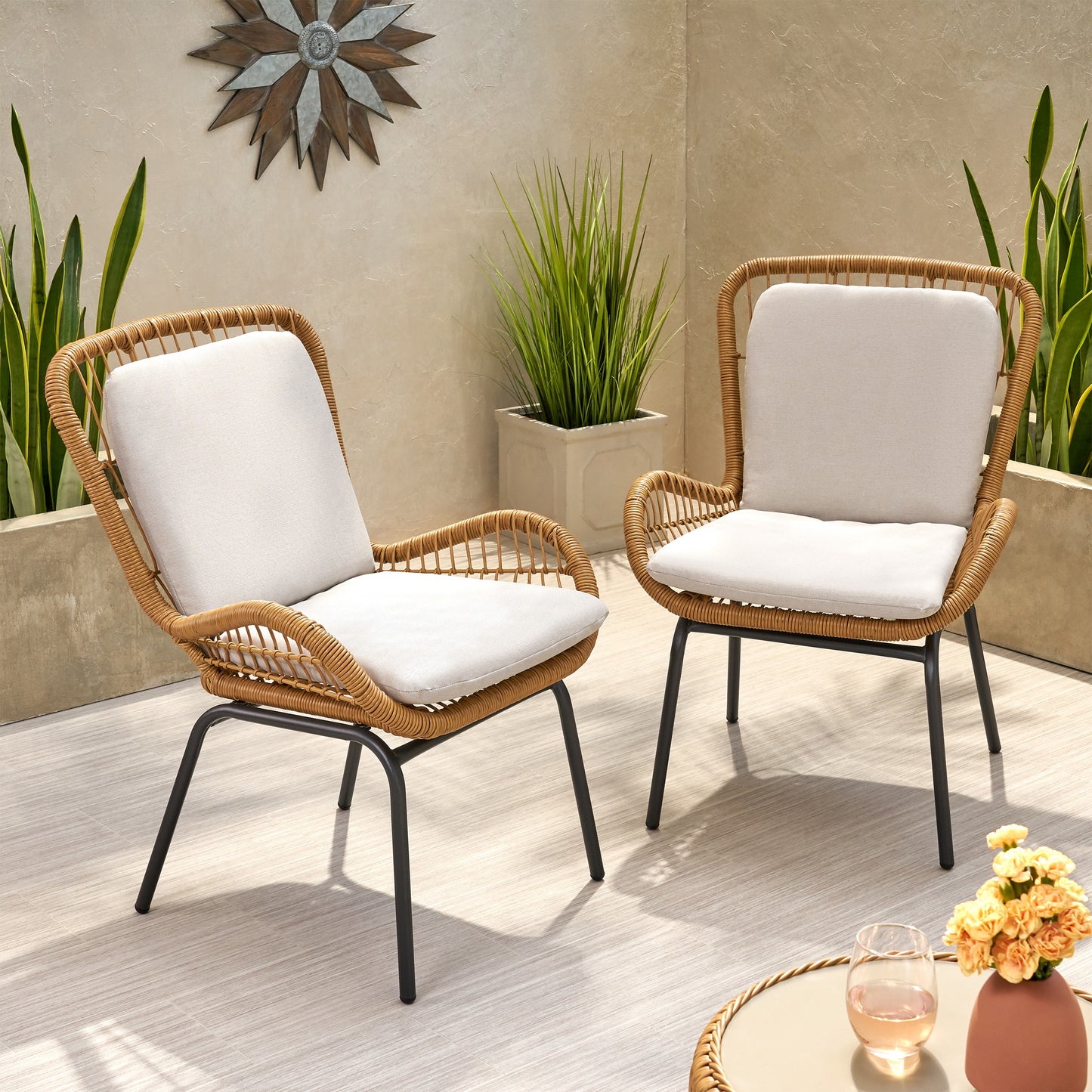 Wicker patio chair with plush white cushion and modern black metal frame
