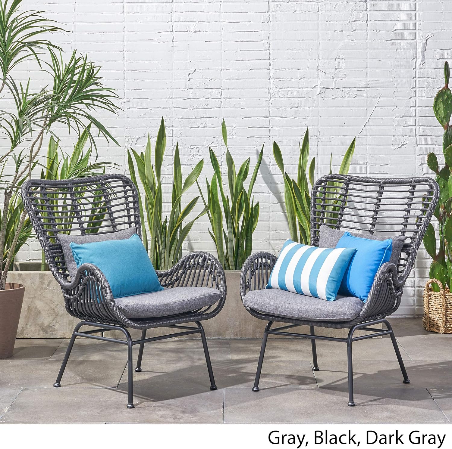 Pair of dark gray woven rattan patio chairs with gray seat cushions and blue accent pillows