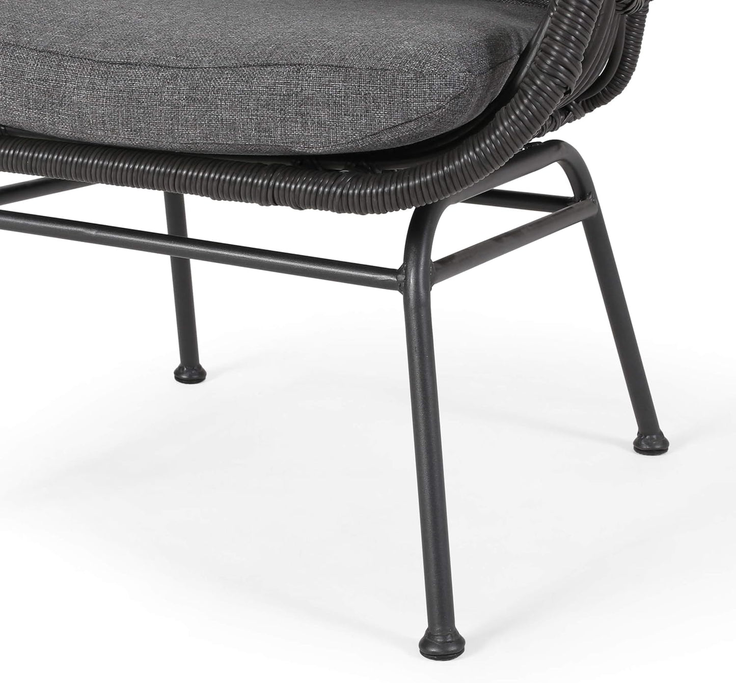 Closeup of a dark grey upholstered wicker patio chair with metal legs on a white background