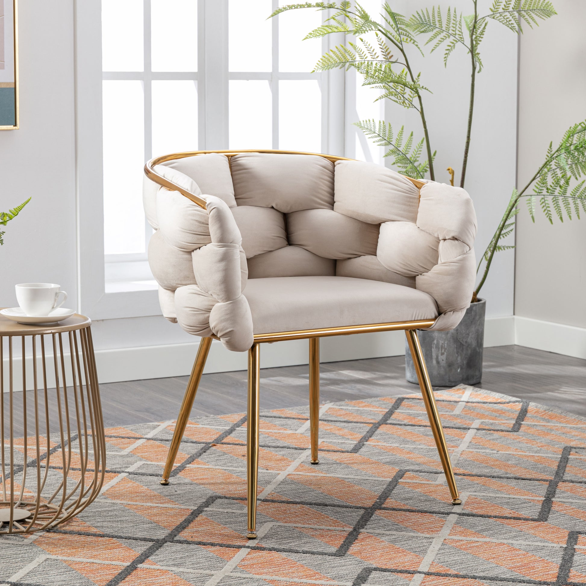 Plush cream accent chair with gold frame and tufted upholstery a stylish addition to living spaces