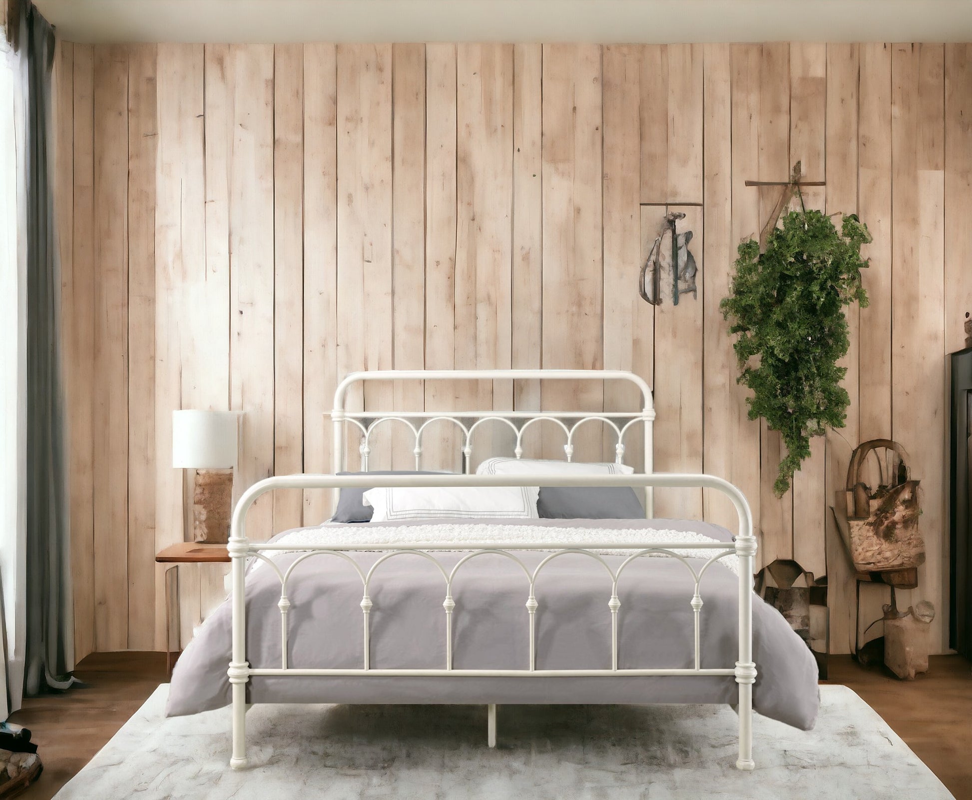 White wrought iron queen bed frame with grey bedding and decorative pillows