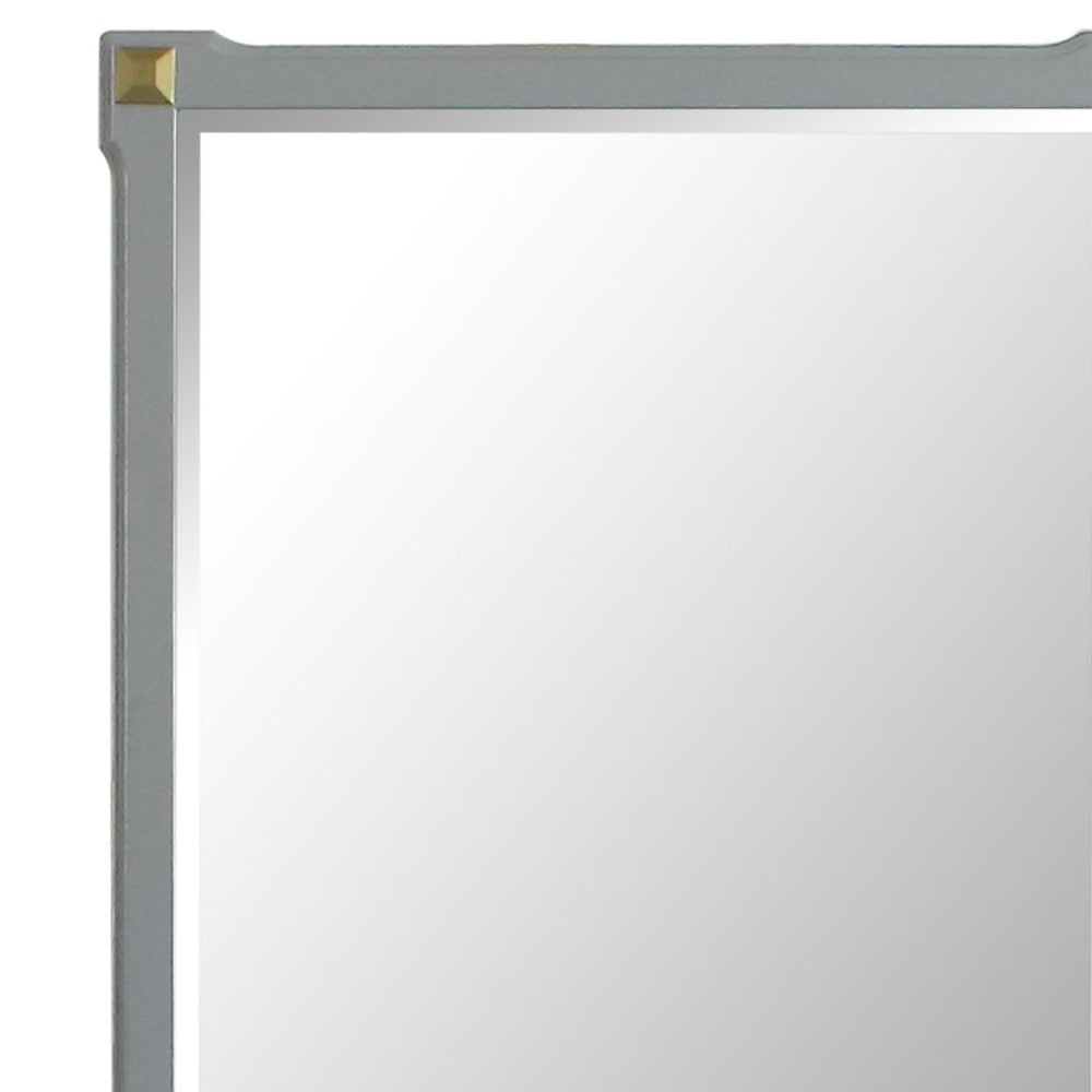 Minimalist grey framed mirror with brass corner accent