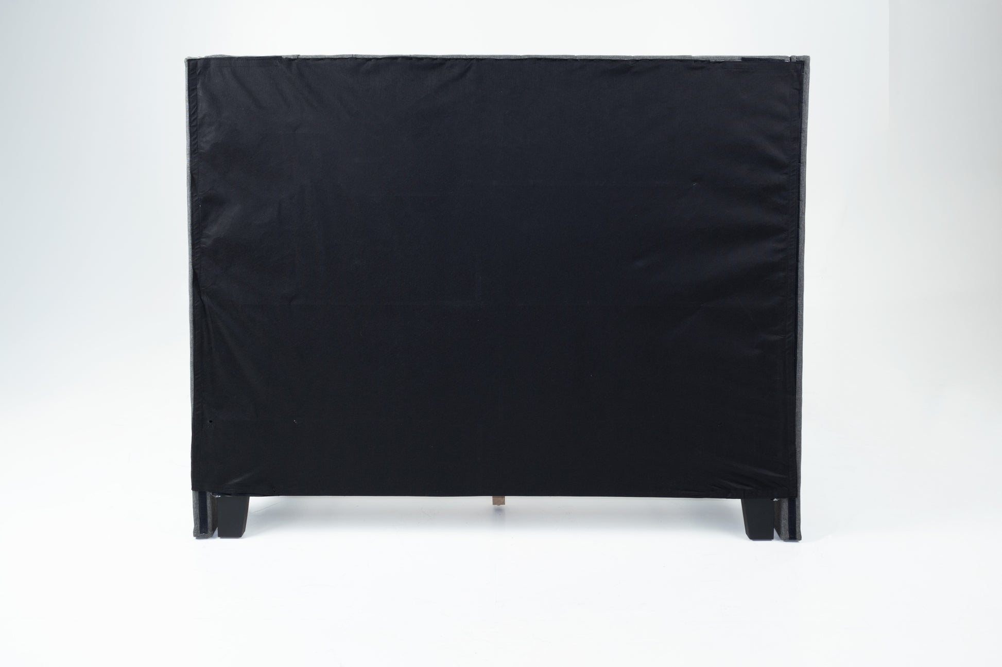 Black upholstered headboard with wooden legs visible