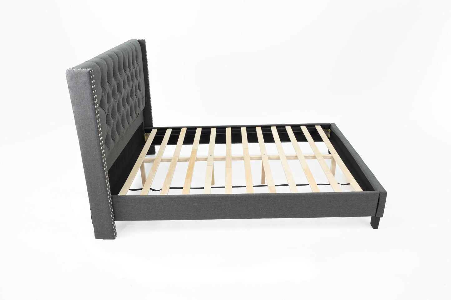 Dark grey upholstered wingback bed frame with diamond tufting and silver nailhead trim