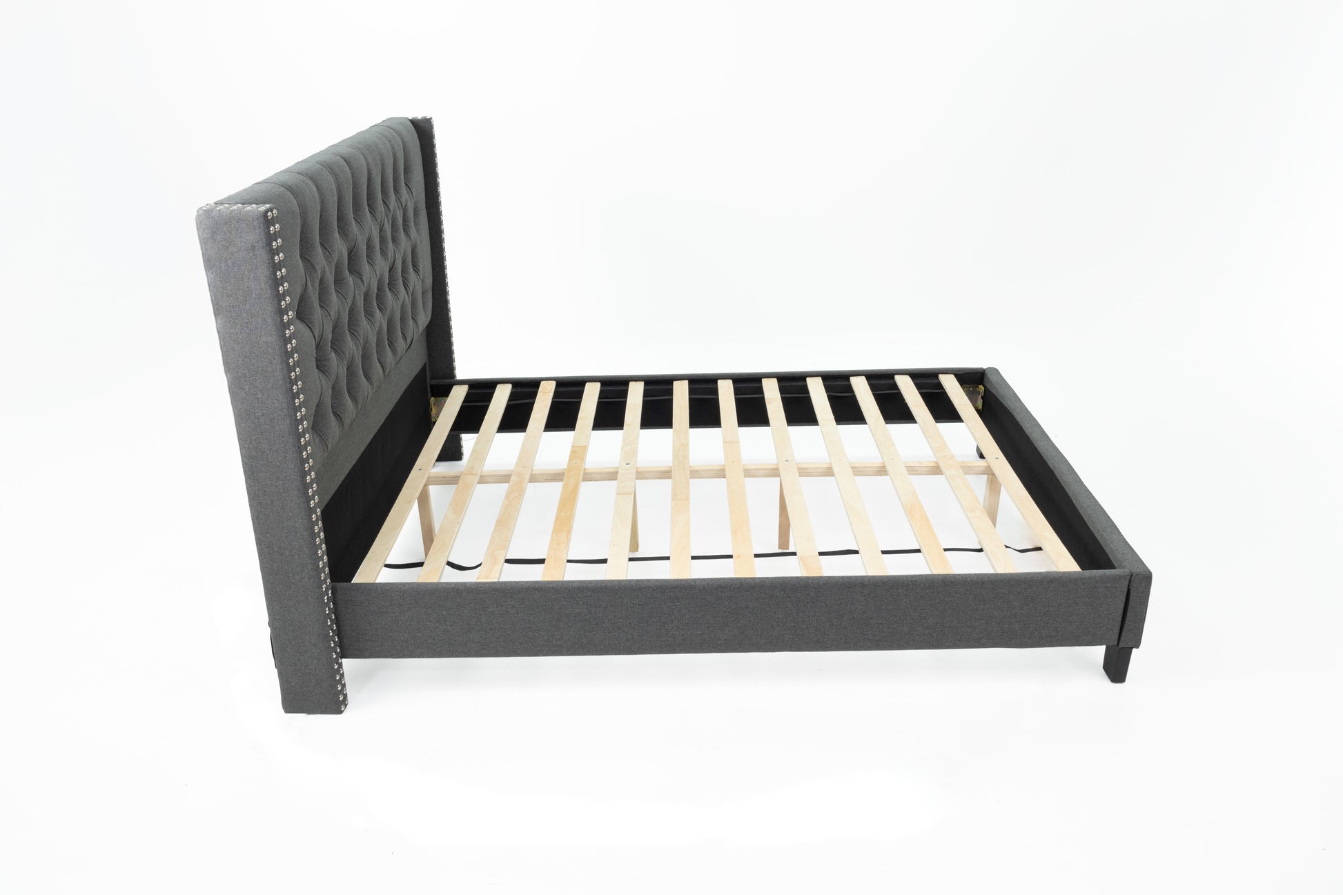 Dark grey upholstered wingback bed frame with diamond tufting and silver nailhead trim