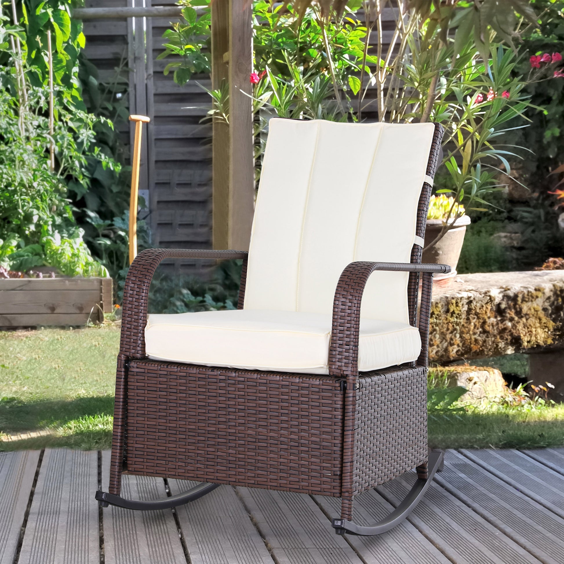 Brown wicker rocking chair with cream cushions on a wooden deck in a garden setting